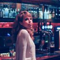 Carmen from Misty River standing at a bar looking at us